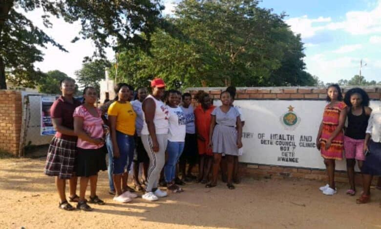 A group posing beside the Dete Council Clinic sign